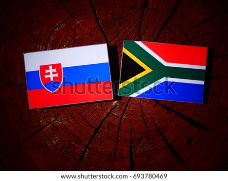 Slovakian flag with South African flag on a tree stump isolated