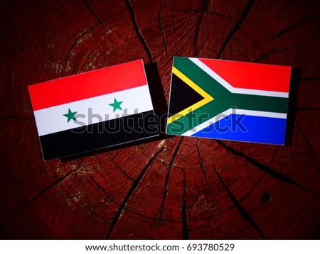 Syrian flag with South African flag on a tree stump isolated