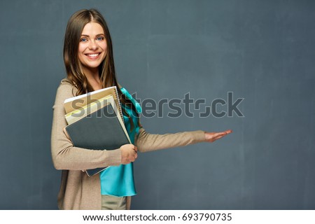 Teacher woman holding empty hand for product. Gray wall background.
