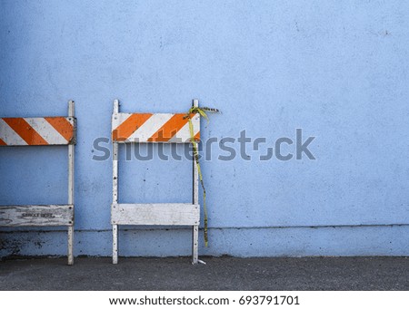 Caution construction sign structures against a blue wall