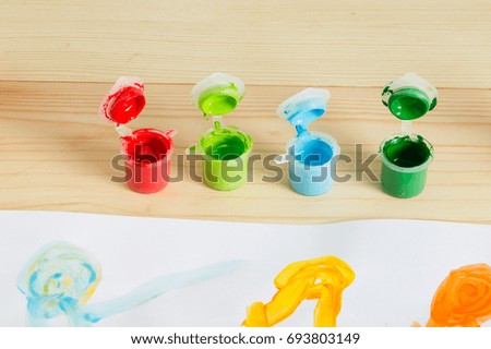 Colorful acrylic paints on the wooden table. Child's art