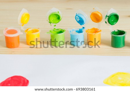 Colorful acrylic paints on the wooden table. Child's art