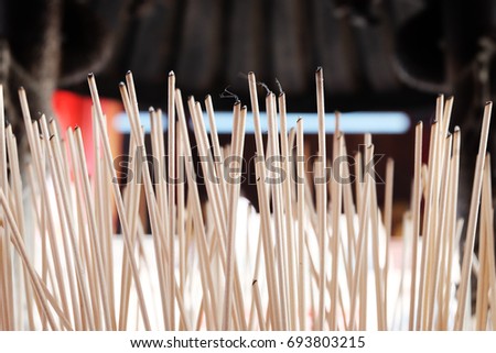 Incense Sticks On The Pot At The Buddha Temple With Blur Black Roof Background,Thailand