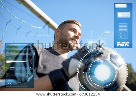sport, technology and people concept - soccer player or goalkeeper with ball at goal on football field