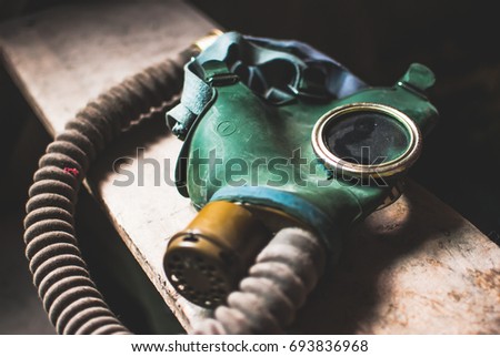 Obsolete retro gas mask laying on the wooden stairs. Equipment used in cases of natural disasters, ecological catastrophes, armed conflicts, fires.