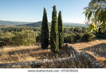 Three cypresses in  in Saint-Saturnin-les-Apt Muehle in Provence, France Royalty-Free Stock Photo #693838606
