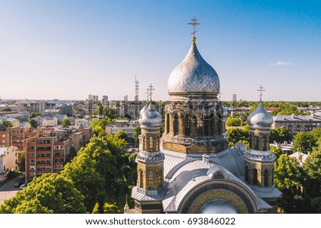 Aerial view on beautiful cathedral with silver roof and golden cross at the top, summer evening time 