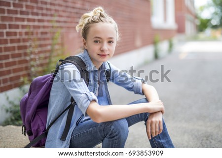 A Nice Pre-teen boy outside at school having good time Royalty-Free Stock Photo #693853909