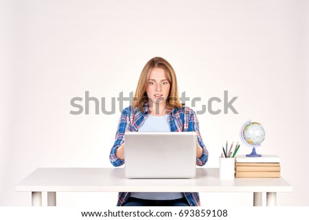 Portrait of teenage red-haired student sitting at desk