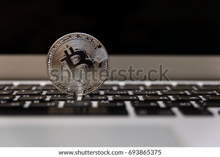 Silver bitcoin on notebook keyboard 
