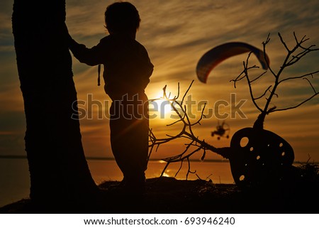the little boy on the sunset para glider
