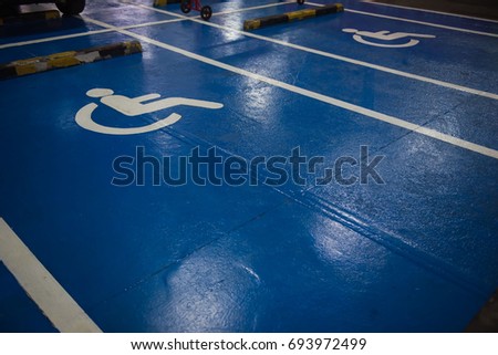 White and blue Handicap symbol car parking of disabled on the floor.