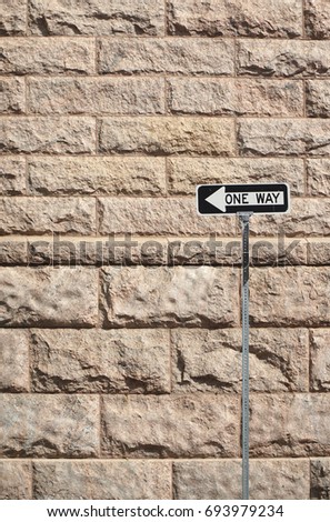 one way sign in front of the brick wall background