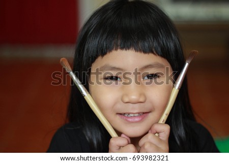 close up portrait of beautiful asian girl playing painted brush. 