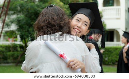 Young beautiful female graduate hugging her mother at graduation ceremony, Pretty female graduate with her mother at university graduation,Congratulate, Age 20-30 years.
