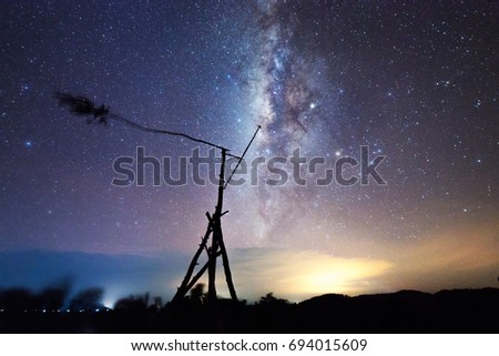 Starry night with Milky Way Galaxy over the silhouette of Windmill. Image contain Noise and Grain due to High ISO. Image also contain soft focus and blur due to Long exposure and wide aperture.