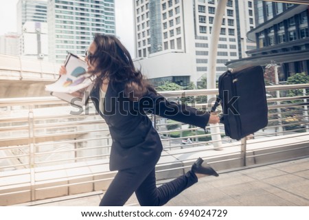 business woman hurry up and running in business city street for rush hour as motion blur Royalty-Free Stock Photo #694024729