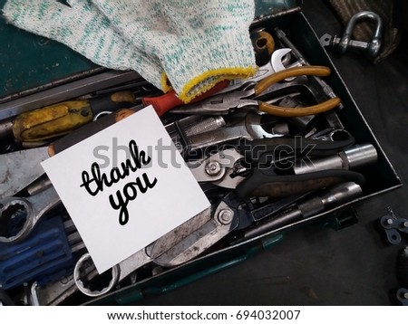 Concept image of tools box and hand glove with paper noted word - Thank you on the black board/selective focus/low light