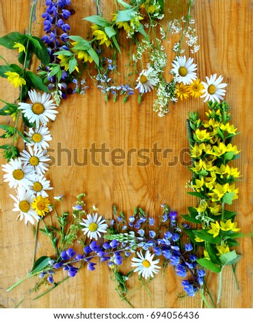 Wildflowers on a wooden background in a frame