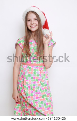 Adorable studio portrait of little girl in santa hat