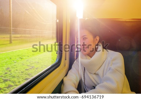 Young beautiful woman traveling looking view while sitting in the train.