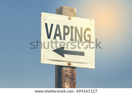 Vaping word and arrow signpost on clear sky background. Motivational sign. Vintage style. 