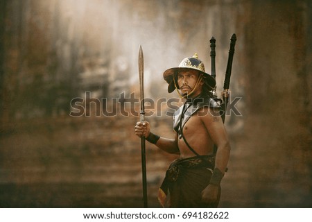 Ancient warrior man of soldier of Bang Rachan District Thailand hold sword fight,Images of dirty middle-aged fighters and swords. Smoke cloud on a black background.Thailand.vintage style