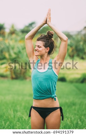 Smiling Woman Doing Yoga and Meditating on Meadow
