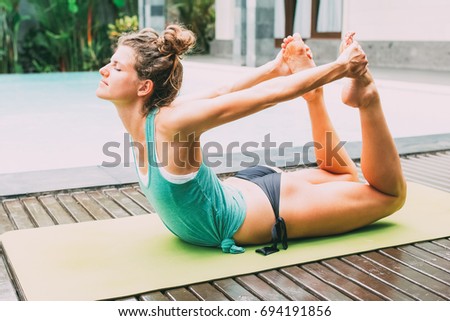 Sporty Woman Doing Yoga Bow Pose Near Pool