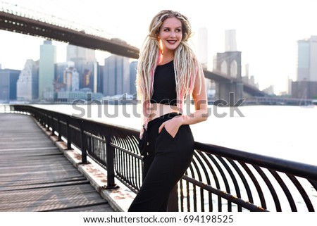 Young woman travel in USA , posing on New York, amazing view on Manhattan, stylish urban image, unusual dreads hairstyle, panoramic city. Street style.