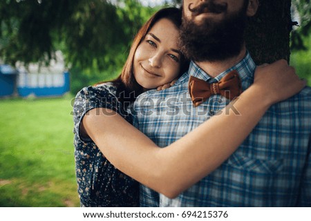 wife affectionately hugging husband while standing in garden