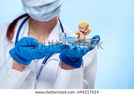 Woman doctor in medical clothes on a blue background holds a petri dish, pediatrician, medicine.