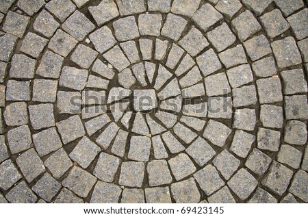 Old grey pavement of cobble stones in a circle pattern in an old medieval european town. Royalty-Free Stock Photo #69423145