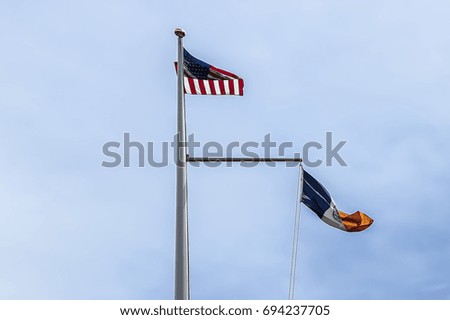 United states of America and New York city flags over clear blue sky 
