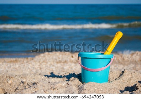 Kid bucket with a scoop on seashore