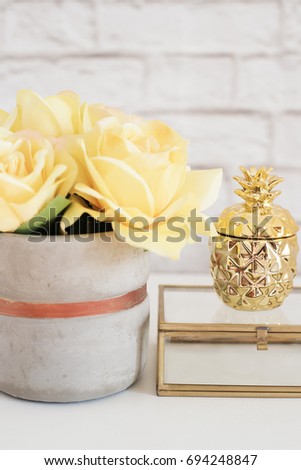 Feminine workplace concept. Freelance fashion comfortable femininity workspace with flowers and golden pineapple on white background. Yellow and gold. Vertical image