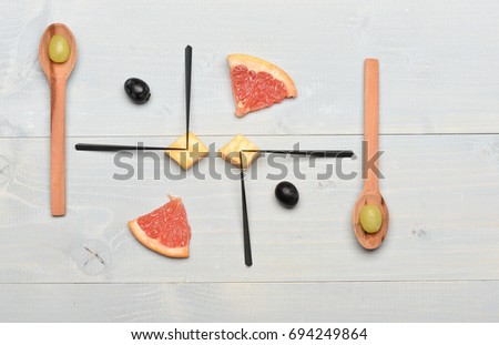 Composition of grapes and grapefruit. Art and healthy food concept. Tasty snack with cheese and summer fruit, top view. Food on vintage background. Wooden spoons, skewers and food making picture.