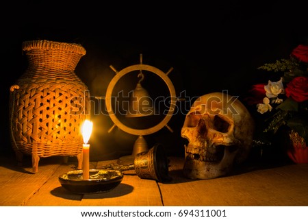 Awesome pile of skull on a brown wooden plank background and wooden bell. Still life style or selective focus and adjustment color for background.