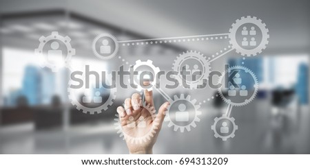 Close of woman hand touching gears on screen with finger and office at background