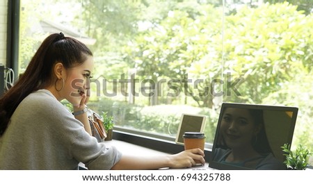 The working woman with laptop and hot coffee cup in the cafe
