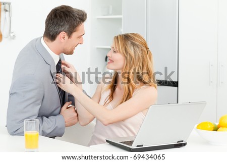 Woman adjusting the tie of her husband at home