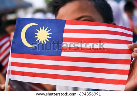 Malaysian primary students with Malaysian Flag during the celebration of Hari Kemerdekaan, the Independence Day of Malaysia.