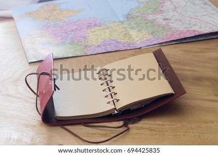 Traveler's things, map and notebook on a wooden background