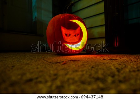 carved pumpkin with cat and moon shaped lighted up