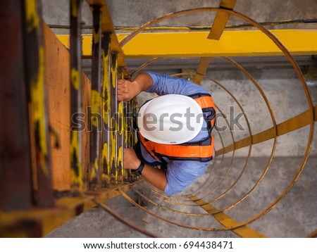 Engineer climb up to the top of overhead crane to inspect and check condition as preventive maintenance plan. Royalty-Free Stock Photo #694438471