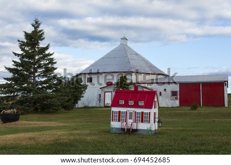 Vintage small decorative house with tin covered farm buildings in the background in Saint-Jean, Island of Orleans, Quebec