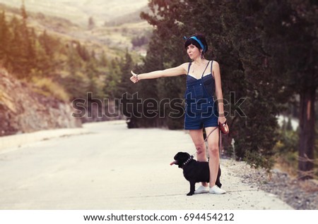 Girl having fun with her pug dog and stopping cars