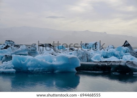 Blue Icebergs in Glacial Lagoon near Jokulsarlon Iceland with Mountains and Glacier in the Background