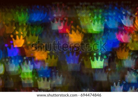 Beautiful background with different colored crown, abstract background, crown shapes on black background, blurry