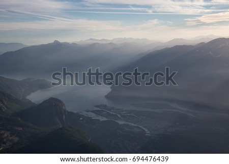 Sun rays coming over Squamish City, Chief Mountain and Howe Sound. Aerial picture taken from an airplane North of Vancouver, British Columbia, Canada.